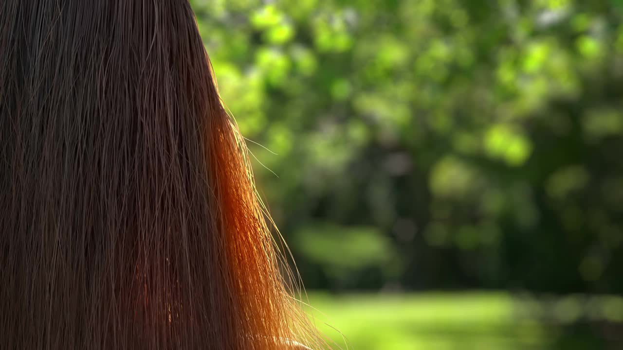 森林的背景上有一个女孩飘动的头发。视频下载