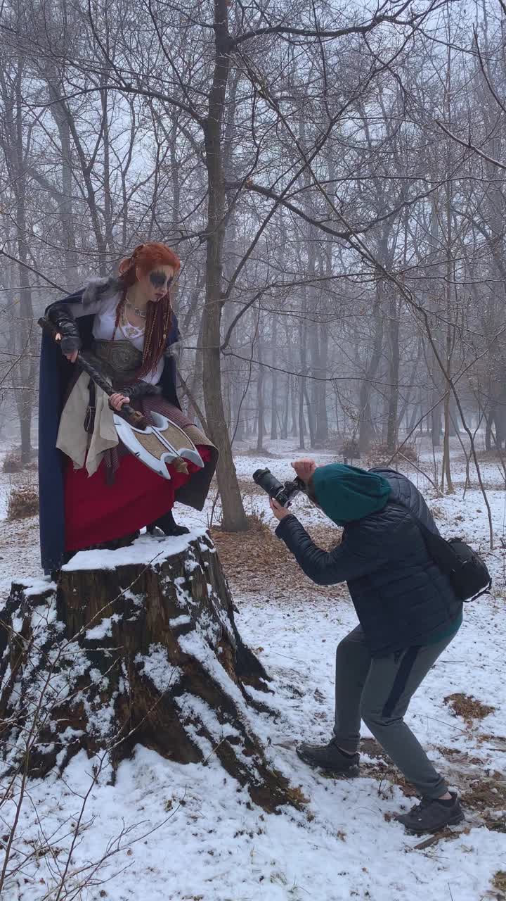男摄影师在冬季拍摄女维京模特。视频素材