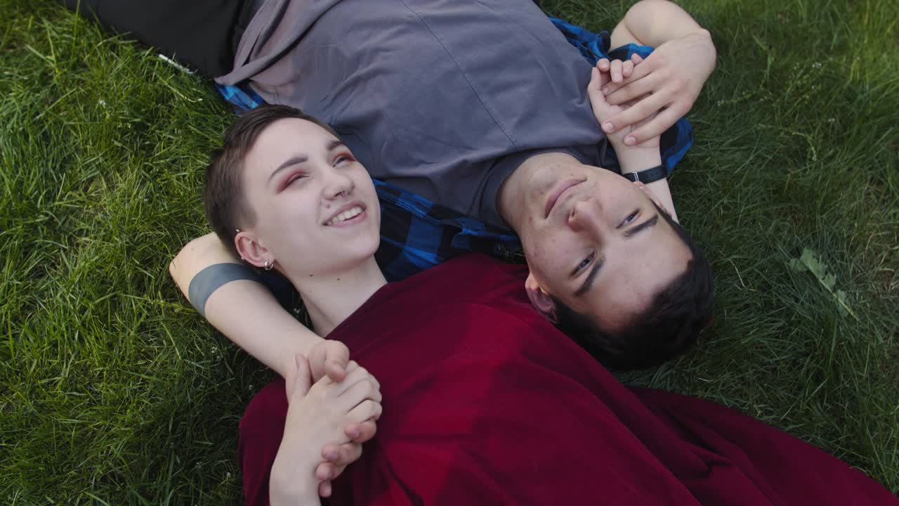 一对青少年情侣躺在草地上视频下载