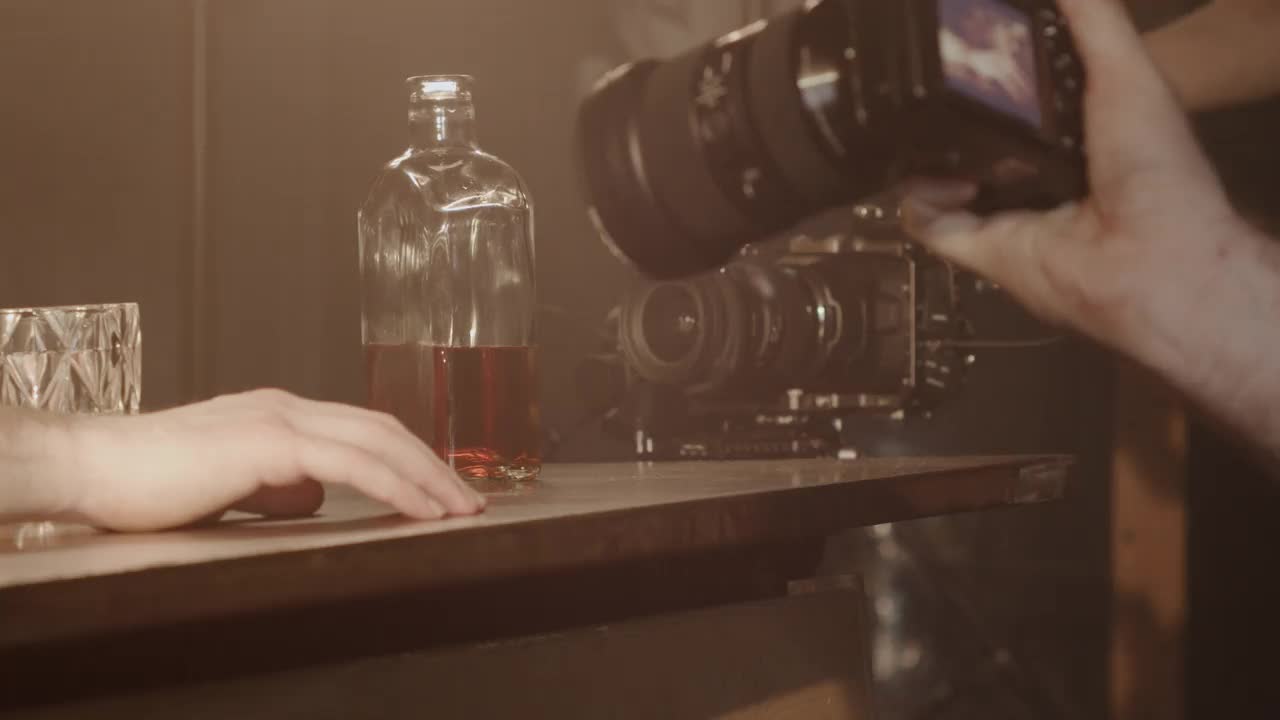 一个在后台的视频，桌上有一个喝醉的男人和一瓶威士忌视频素材