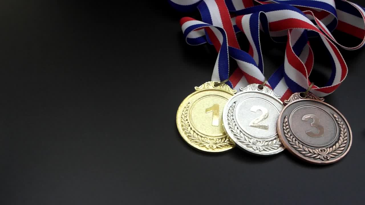 三枚奖牌，注射器，装有液体和药物的瓶子放在黑色的桌子上。视频下载
