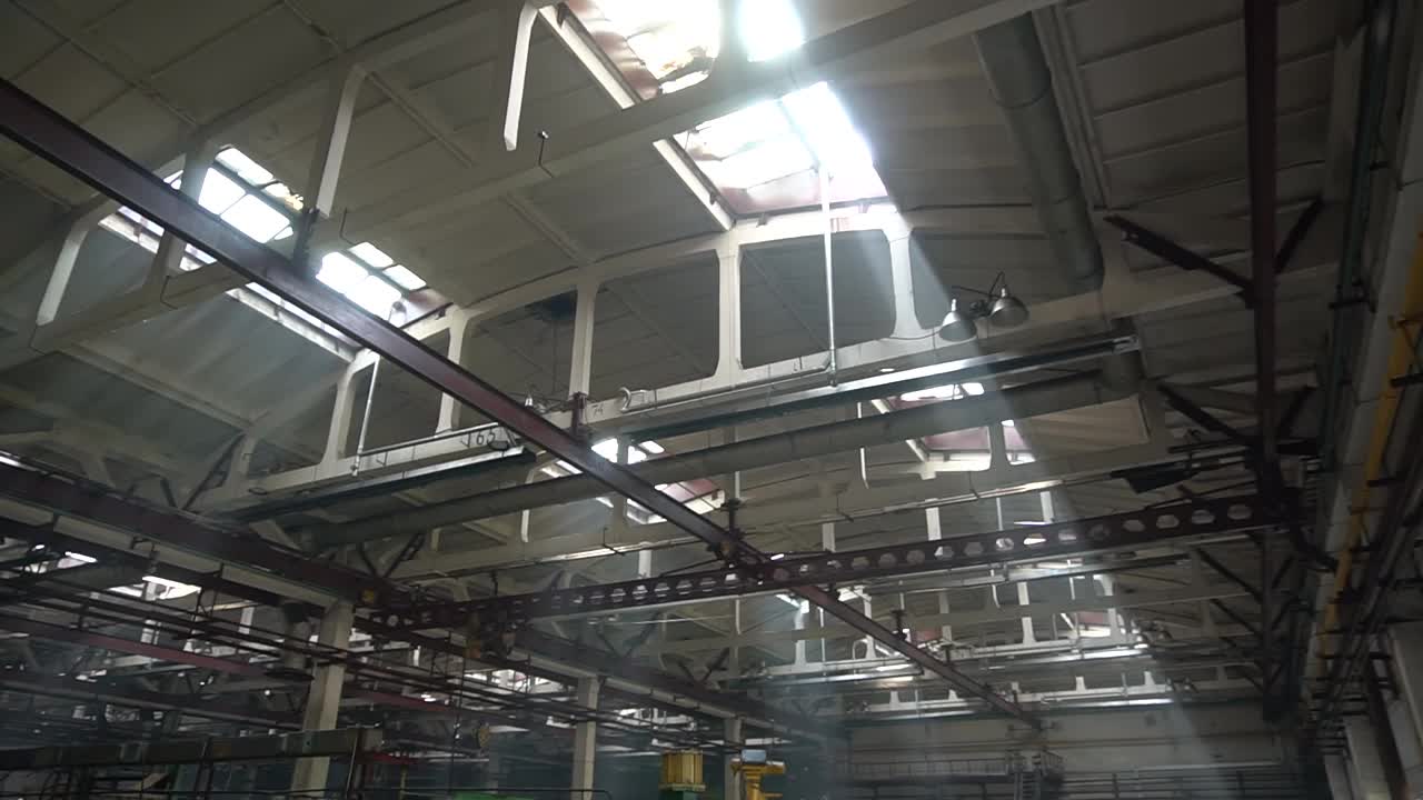 一个工业企业的巨大机库透过天花板上的窗户，阳光照进来视频下载