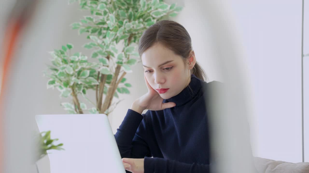 亚洲女性在冠状病毒期间坐在家里上网工作视频素材