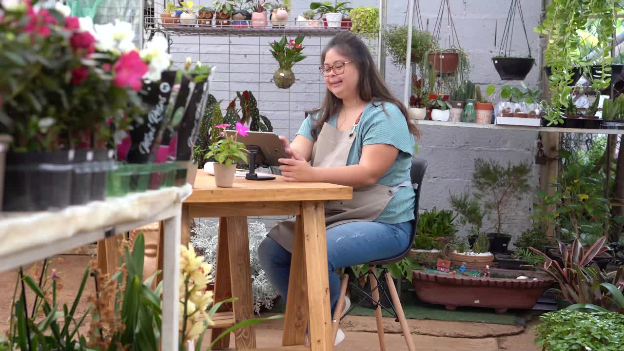 一个患有唐氏综合症的女人在花店工作。视频下载