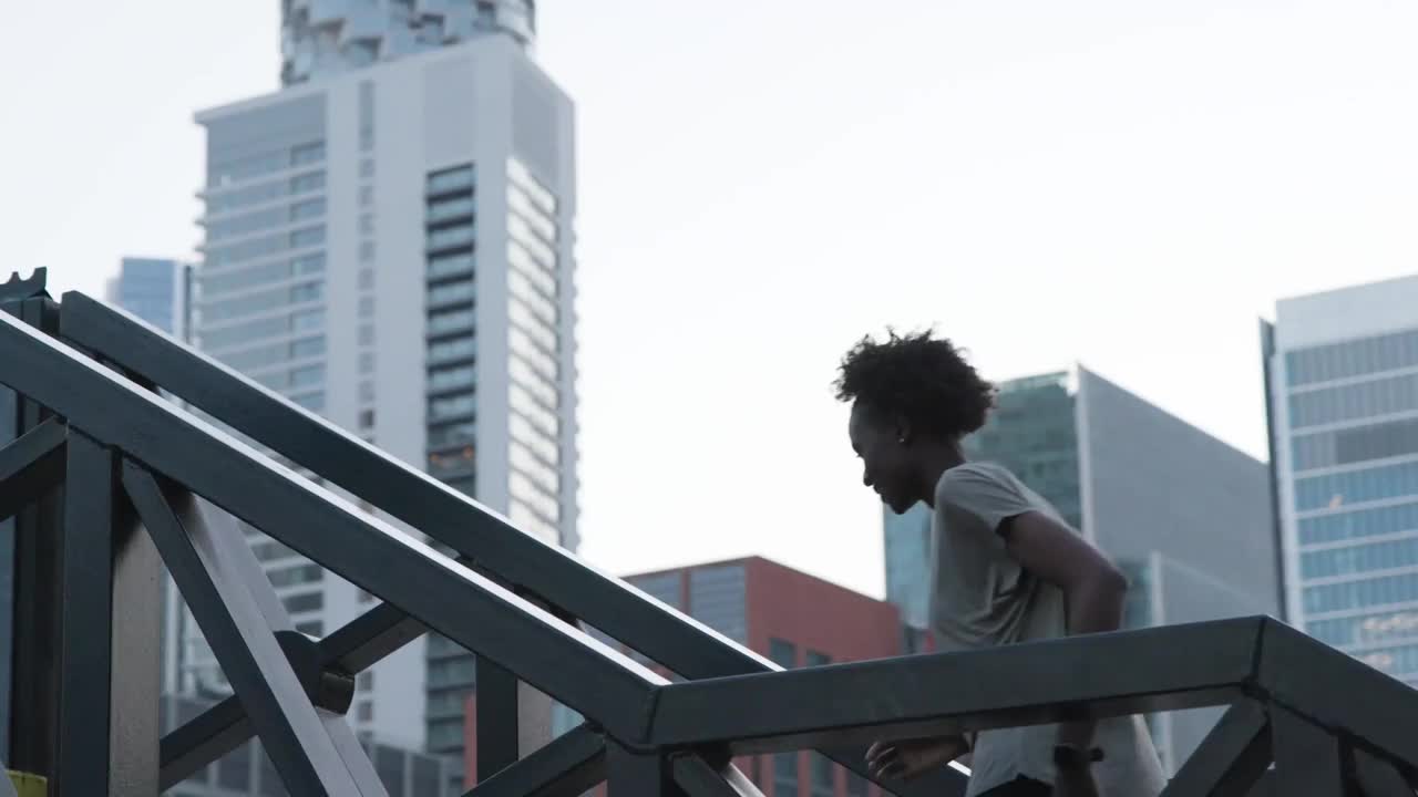 一位女性跑步者正跑过城市中的一座人行天桥视频下载