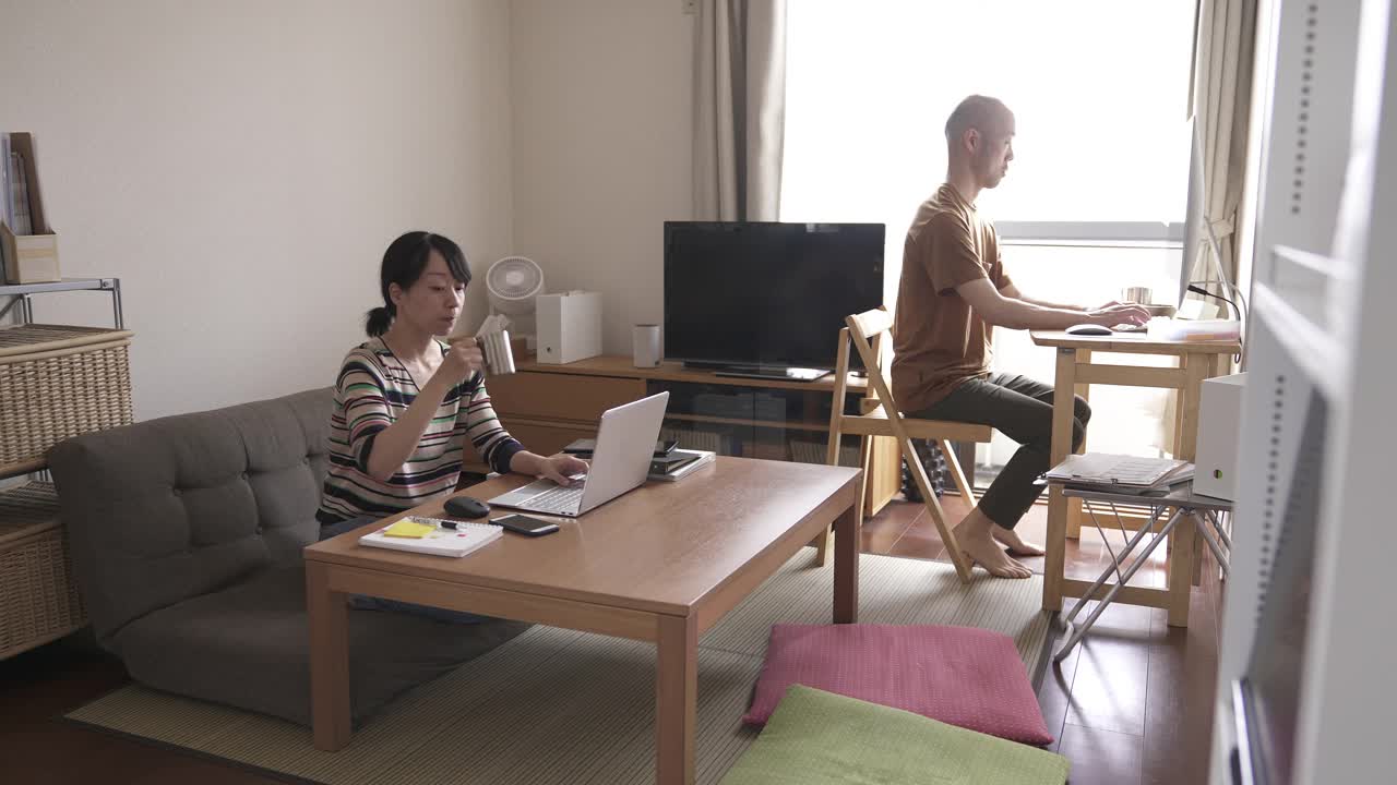 在家里一起工作的亚洲夫妇。视频下载