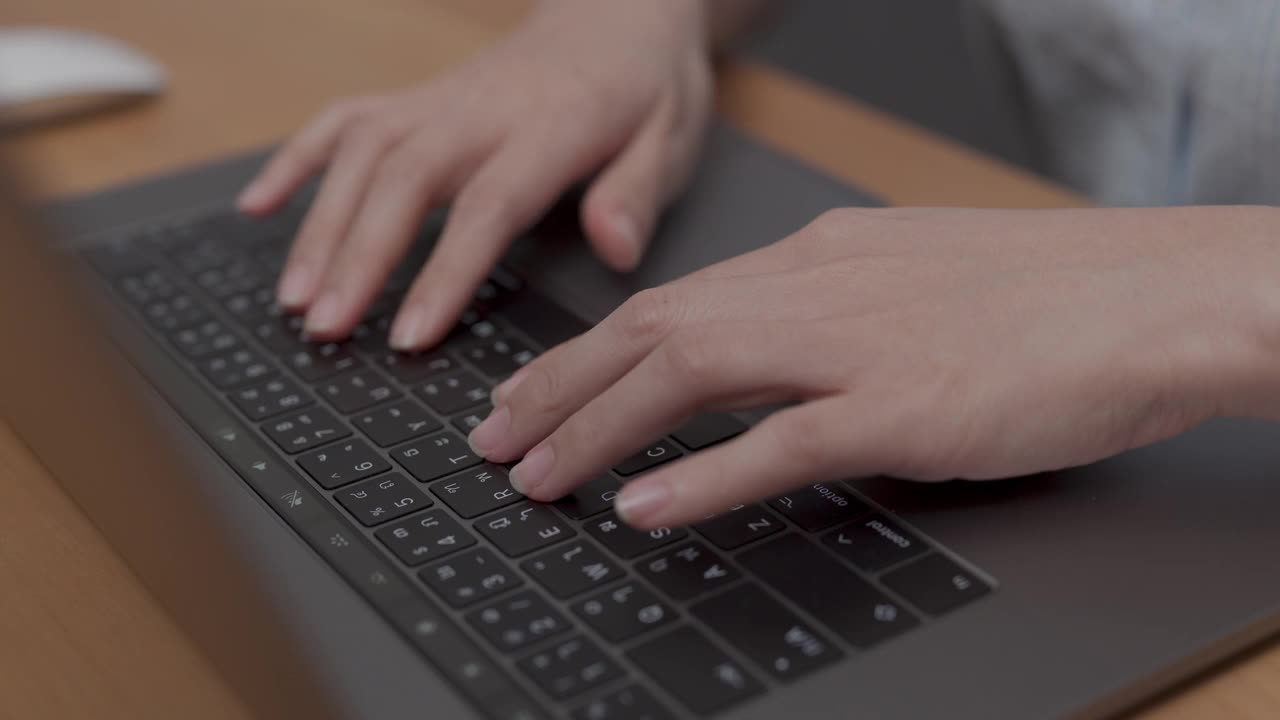 特写，亚洲妇女的手，同时按键盘上的笔记本电脑在家里工作。视频下载