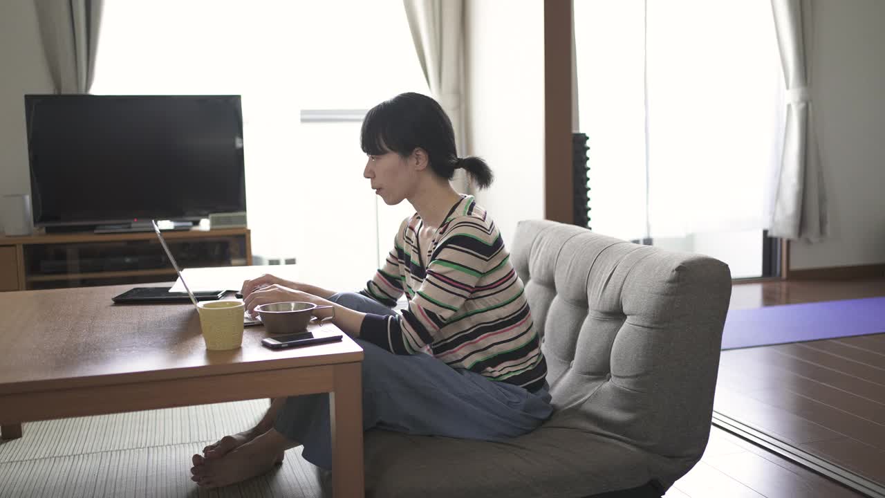 中年妇女在家工作时吃坚果来提神。视频下载