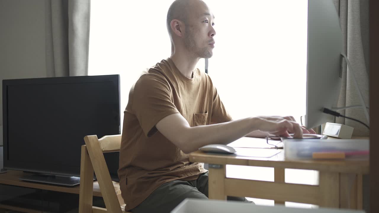 中年人在家工作，在客厅用电脑。视频下载