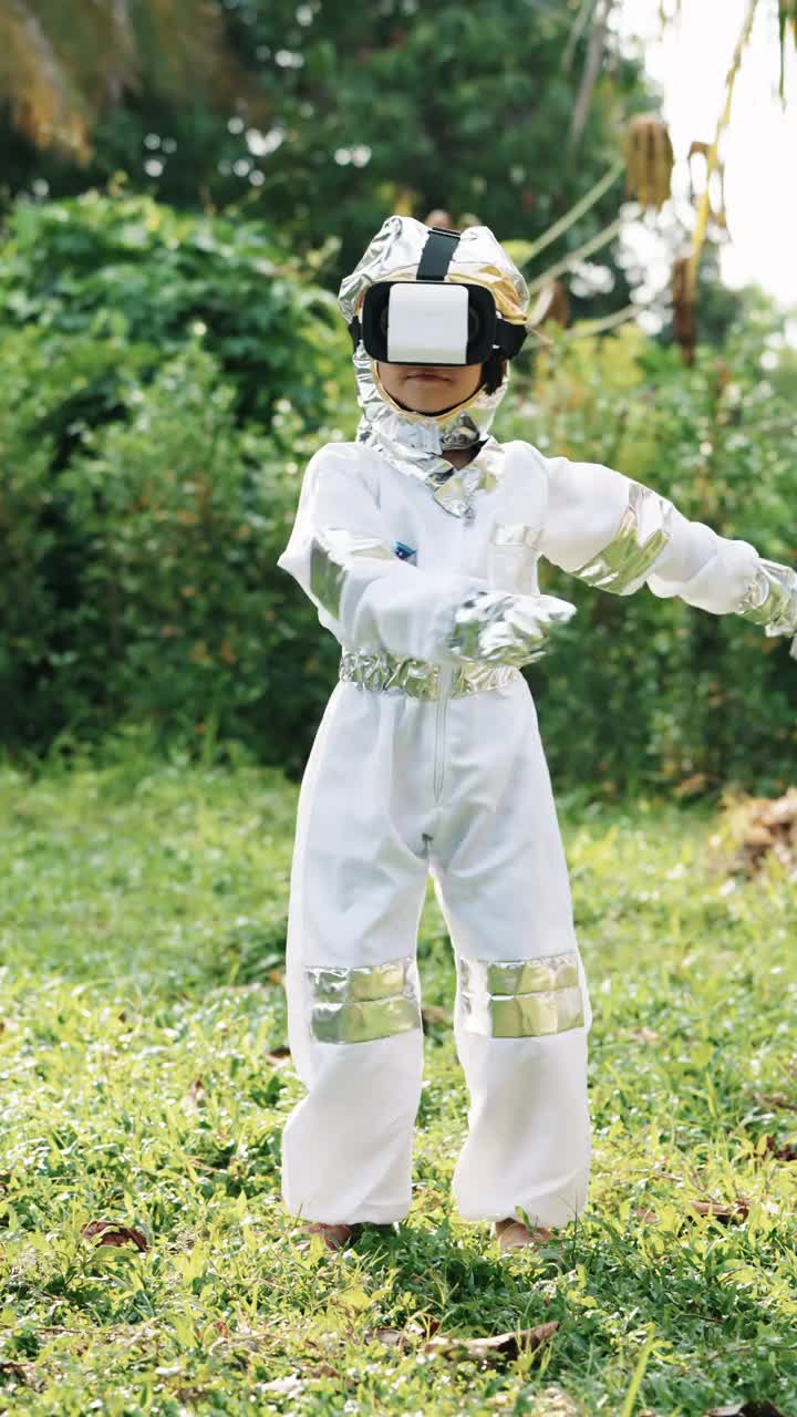 小女孩穿着太空服，戴着虚拟现实眼镜，白天在前院跳舞。视频下载
