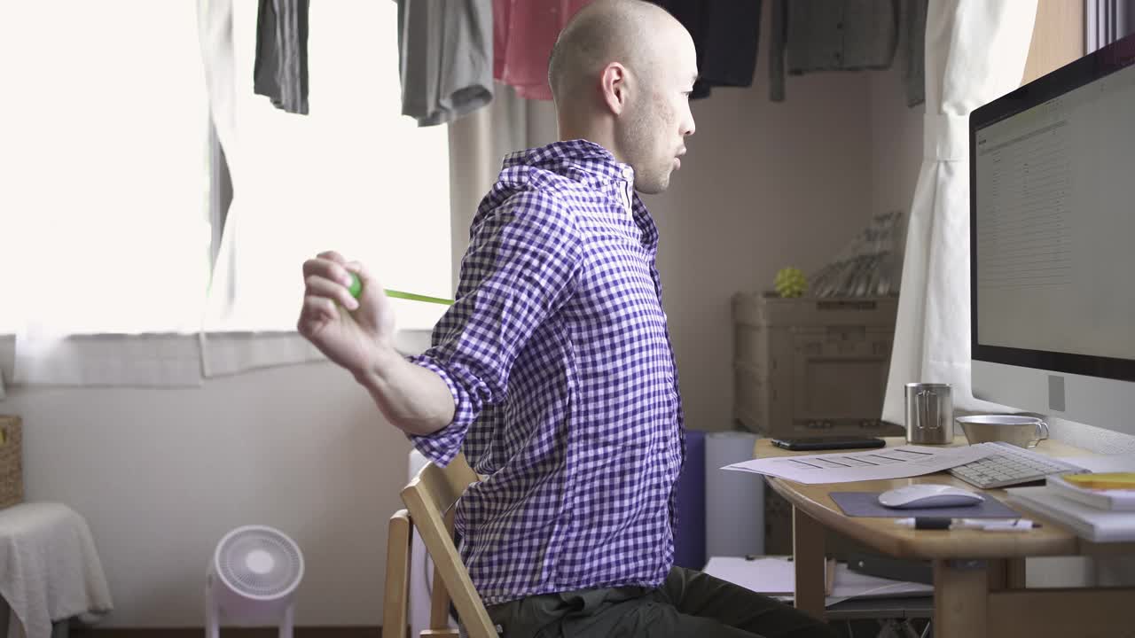 中年男子在家工作时做一些简单的伸展运动。视频下载