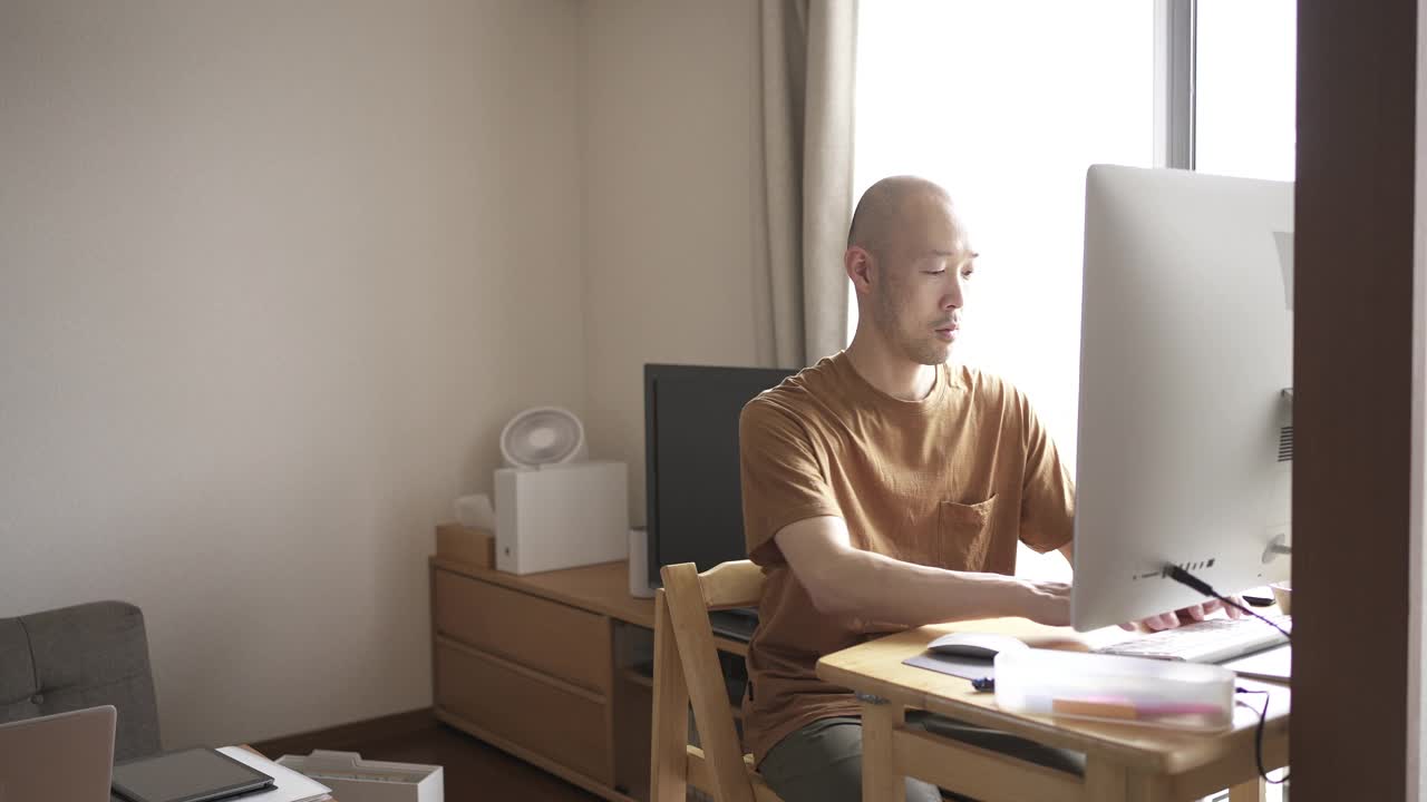 中年人在家工作，在客厅用电脑。视频下载