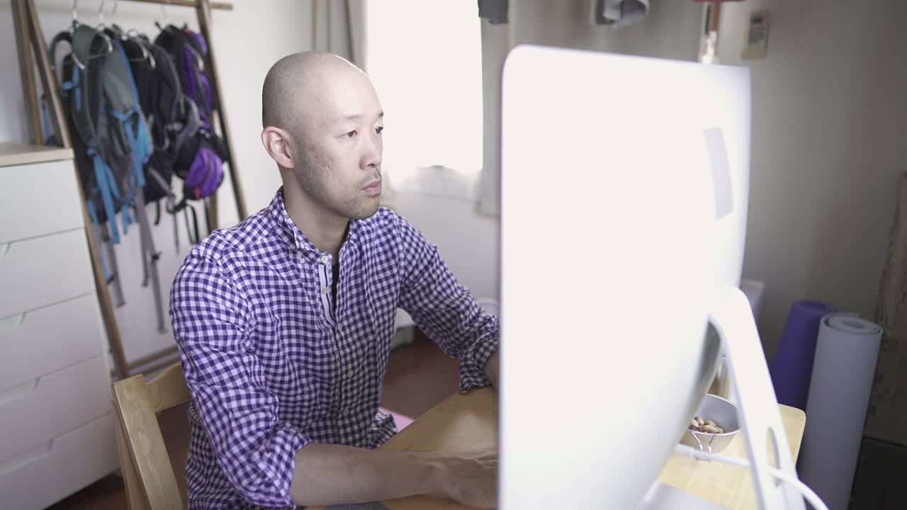 中年人在家工作，在房间里使用电脑。视频下载