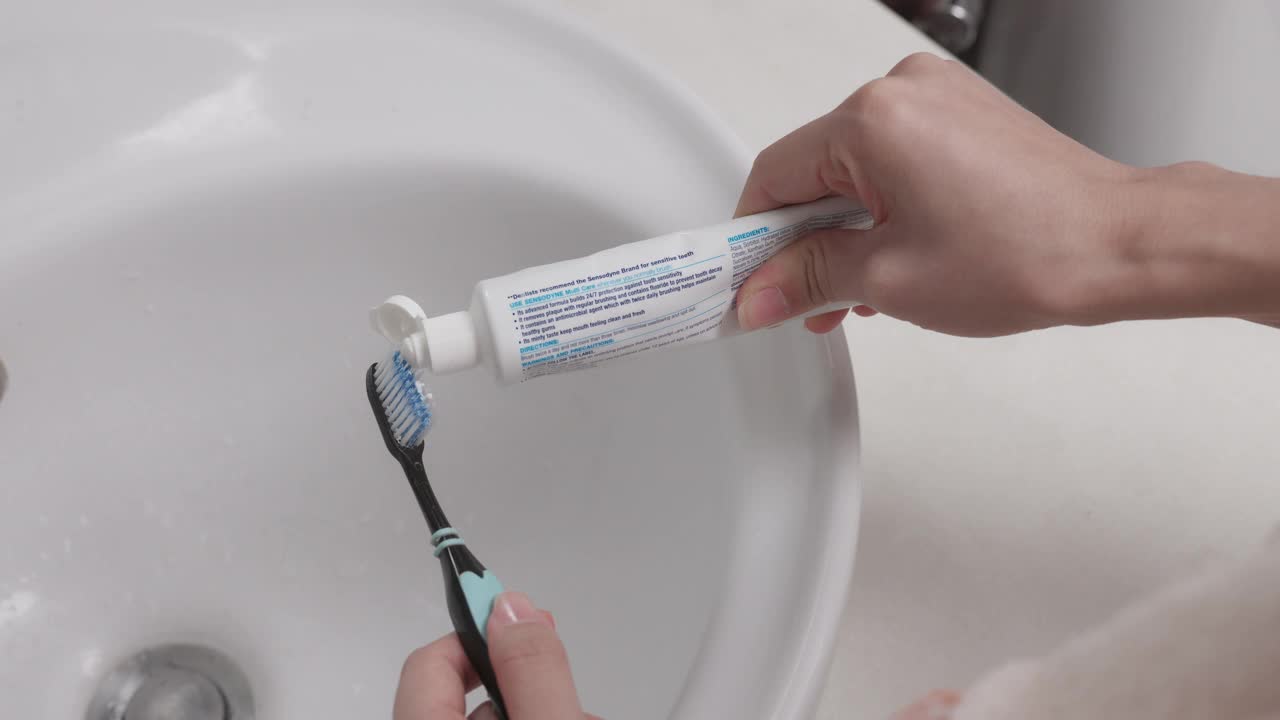 美丽的年轻女子挤牙膏在家里的浴室刷，日常生活方式的概念。视频下载