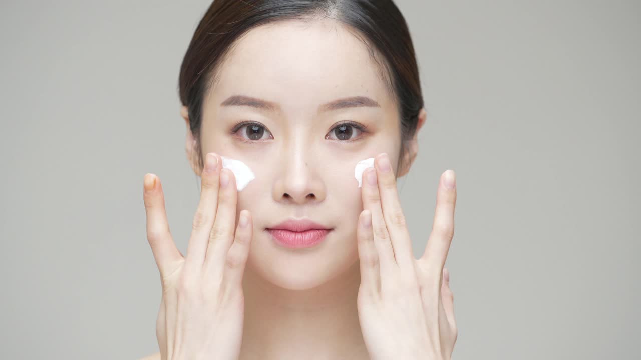 美丽-年轻女子在她的脸上涂面霜工作室/韩国视频素材