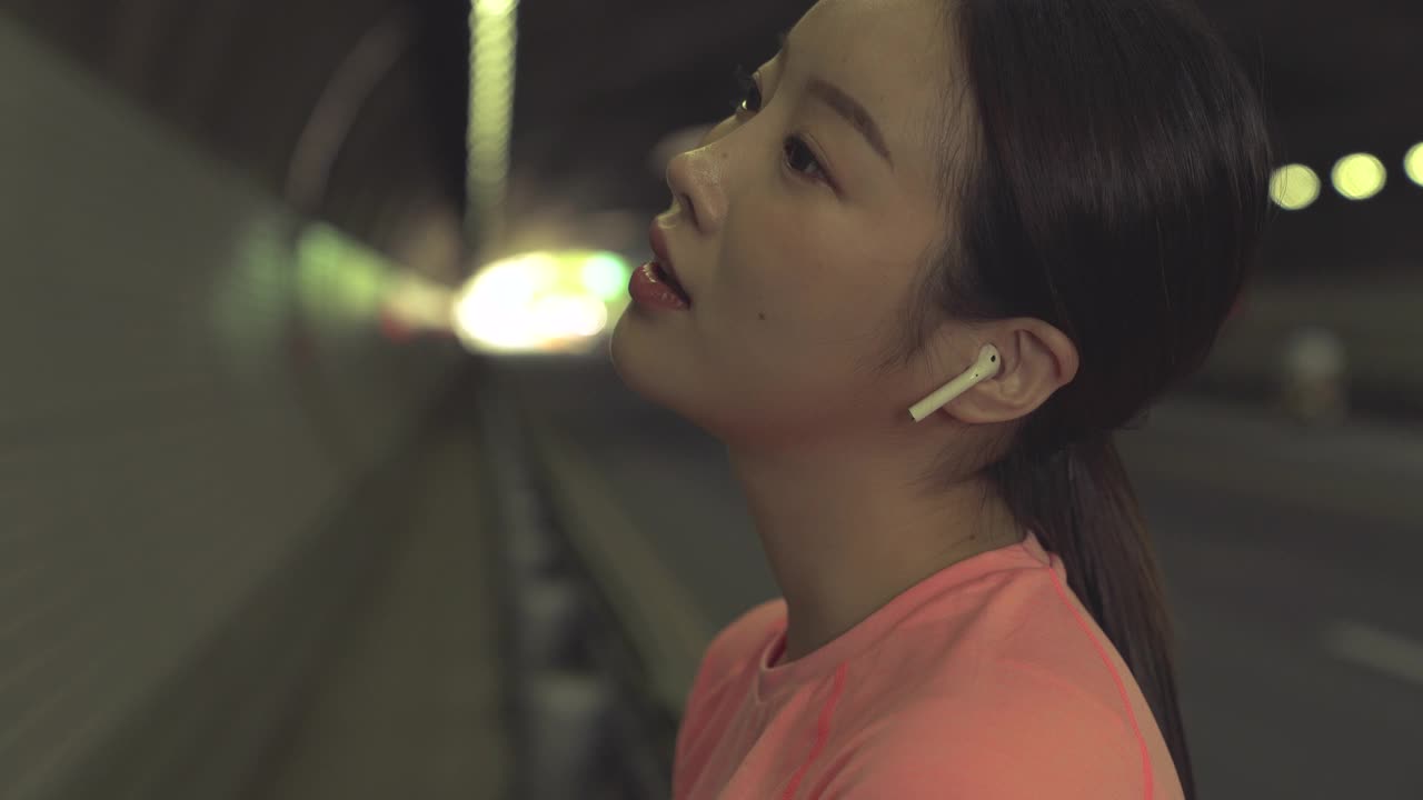 运动和锻炼-回到年轻女子听音乐和休息在隧道在城市/韩国视频下载