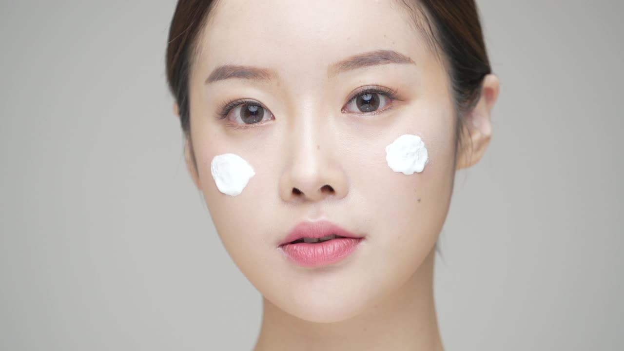 美丽-年轻女子在她的脸上涂面霜工作室/韩国视频素材