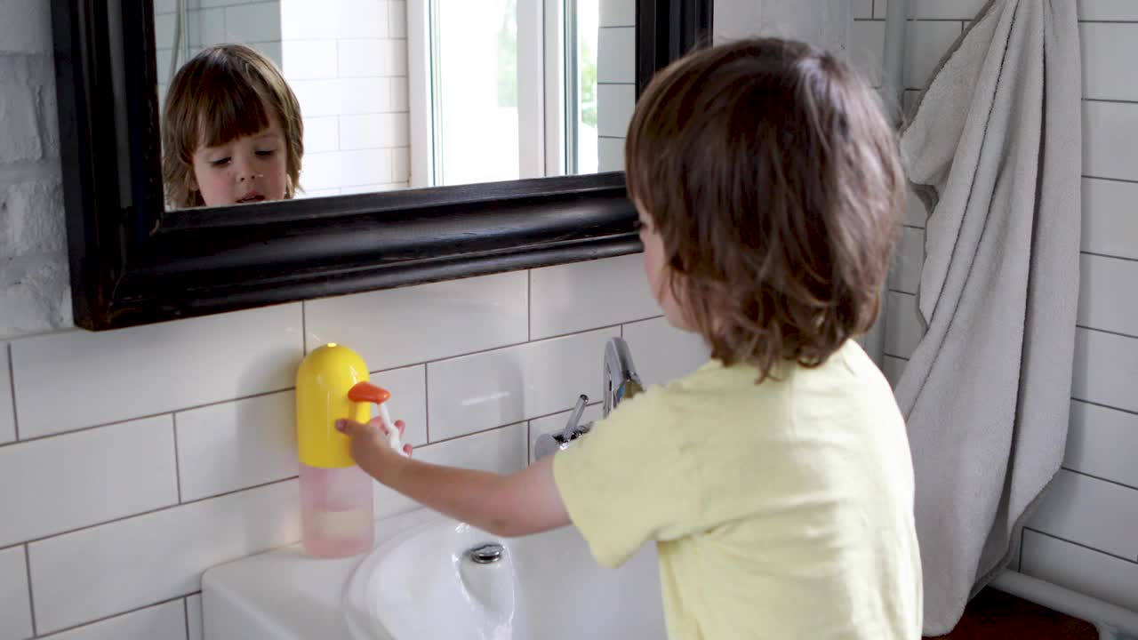 小男孩在浴室里用肥皂洗手。视频下载