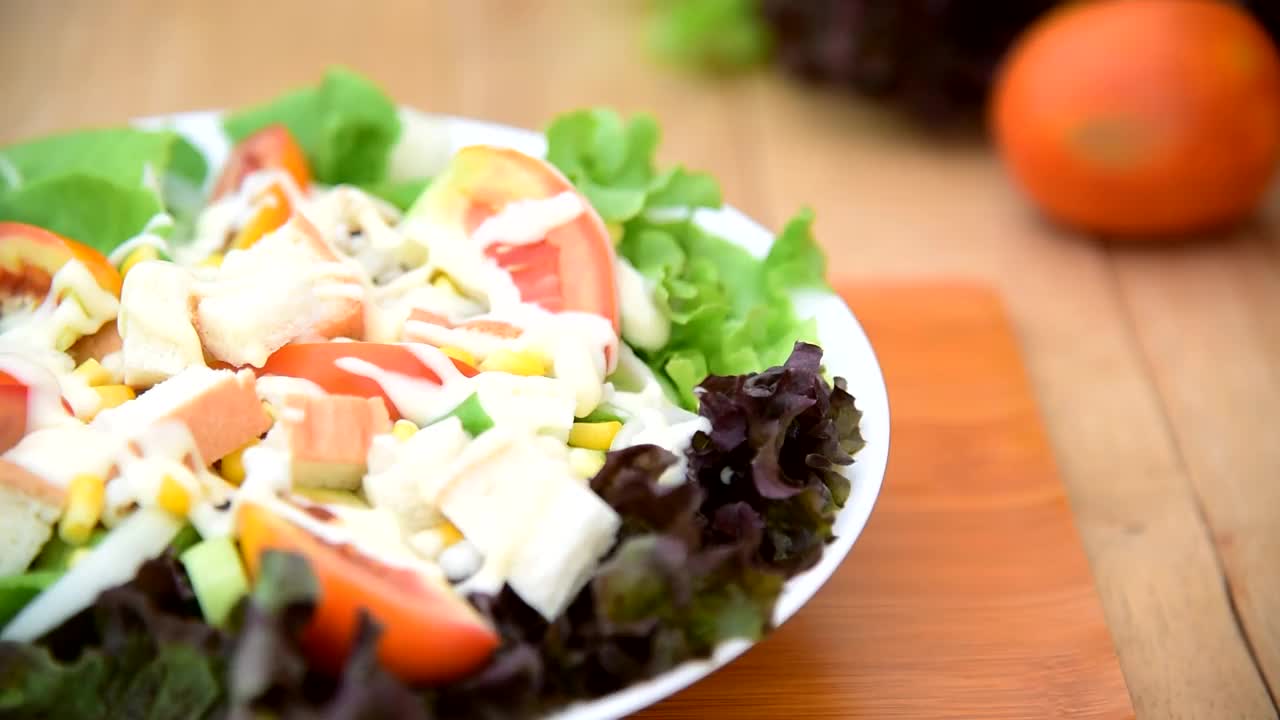 混合新鲜蔬菜沙拉在白色盘子上的木盘子视频下载