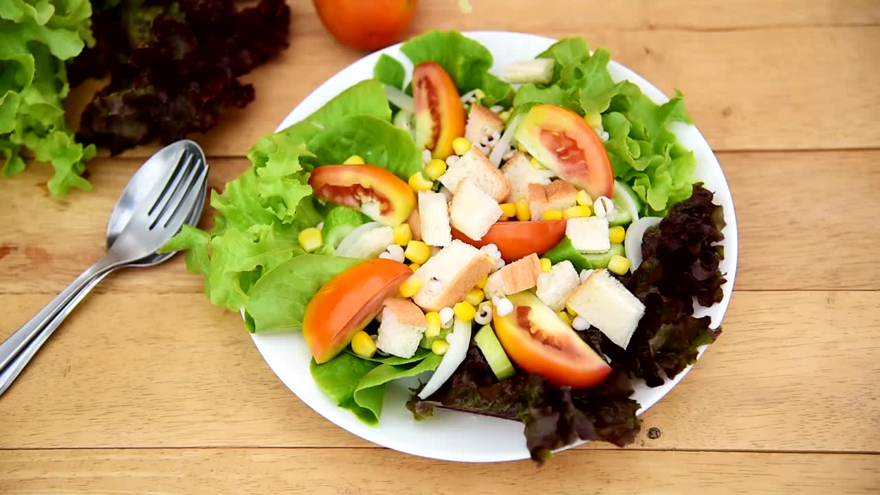 将拌好的蔬菜沙拉倒入白碟中，放在木盘上视频下载