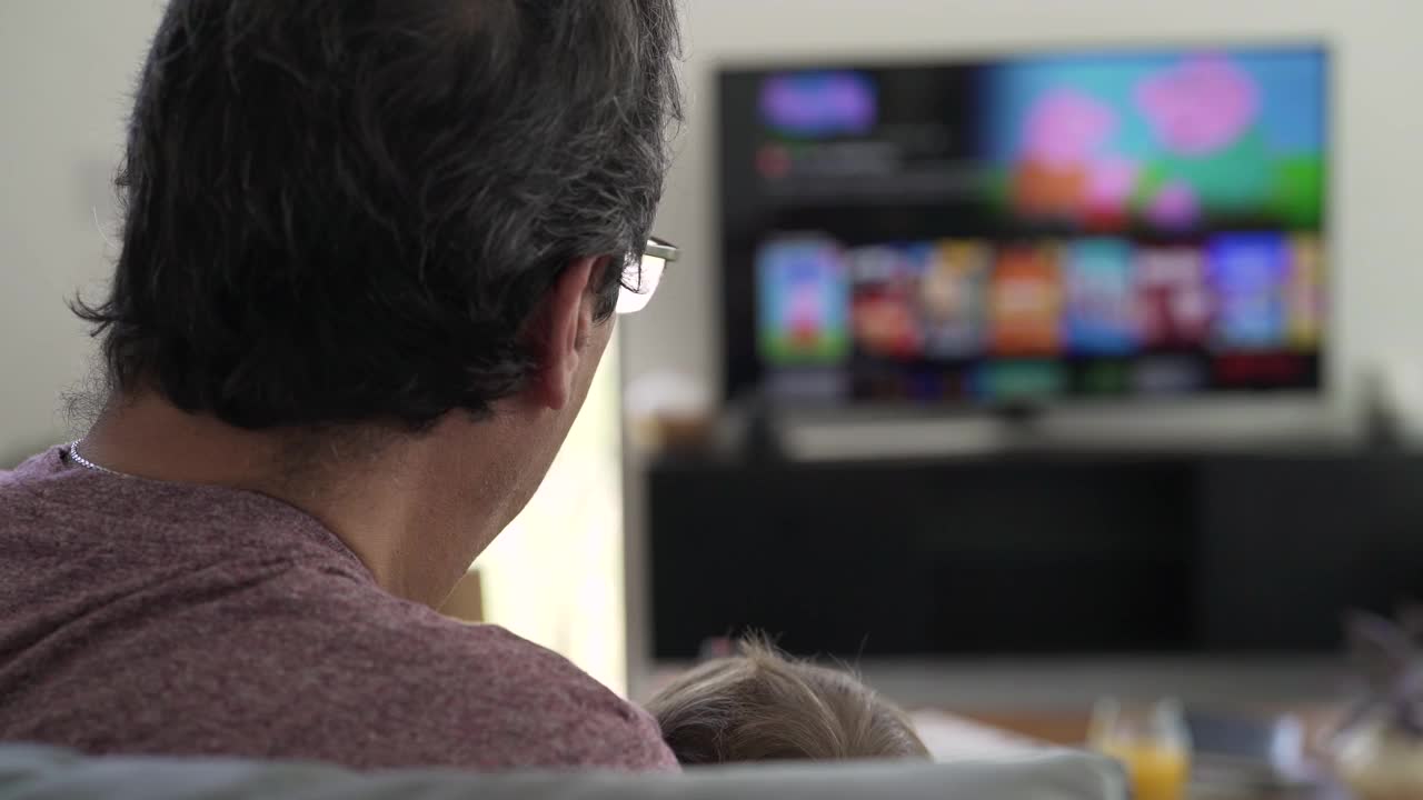 爷爷和孙子在家里看电视视频素材