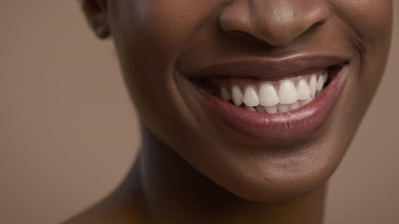 裁剪镜头的非洲裔美国妇女微笑在米色背景视频下载