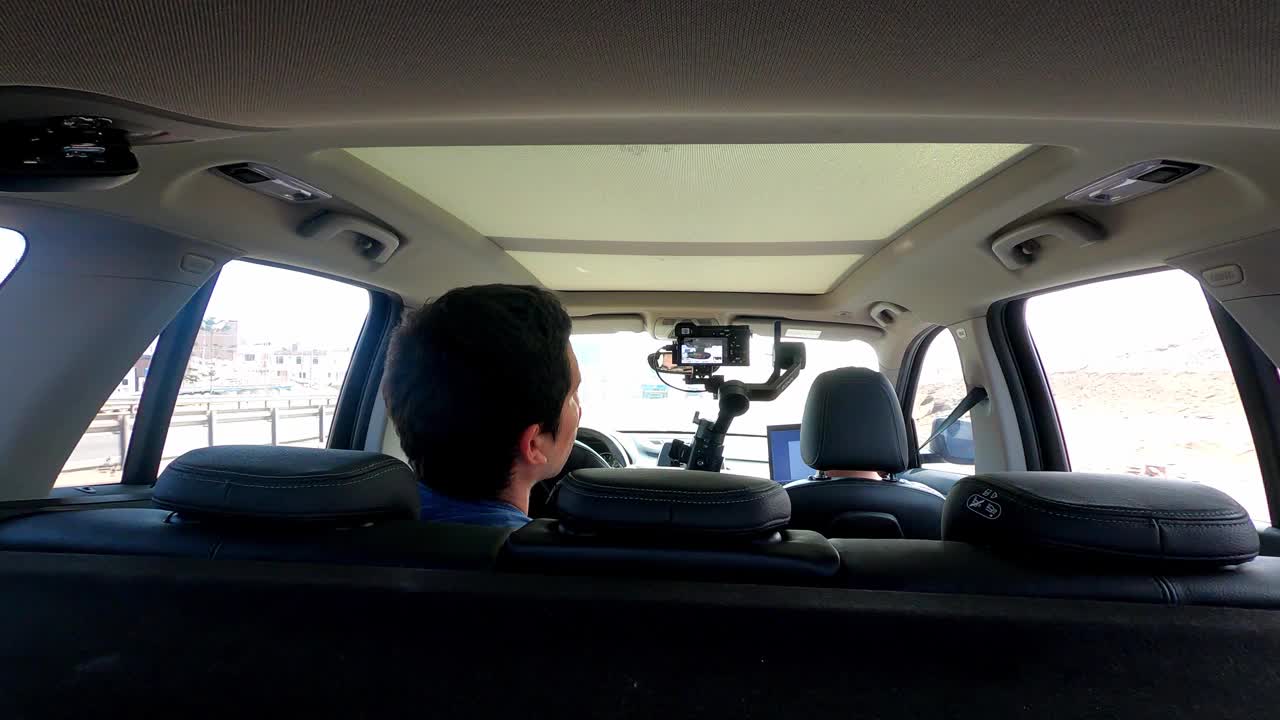 一名男子用4k摄像机拍摄他的朋友的公路旅行视频下载