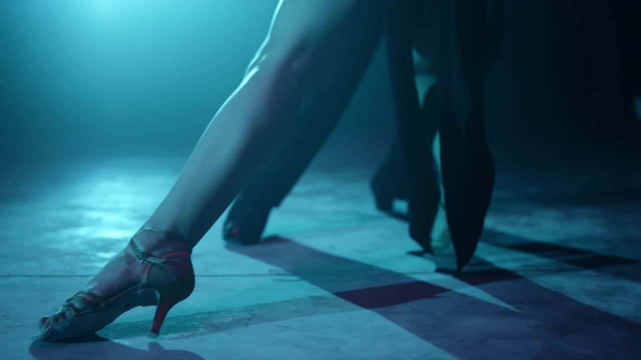 特写舞者的腿在室内跳舞。舞伴的脚跳拉丁舞。视频下载