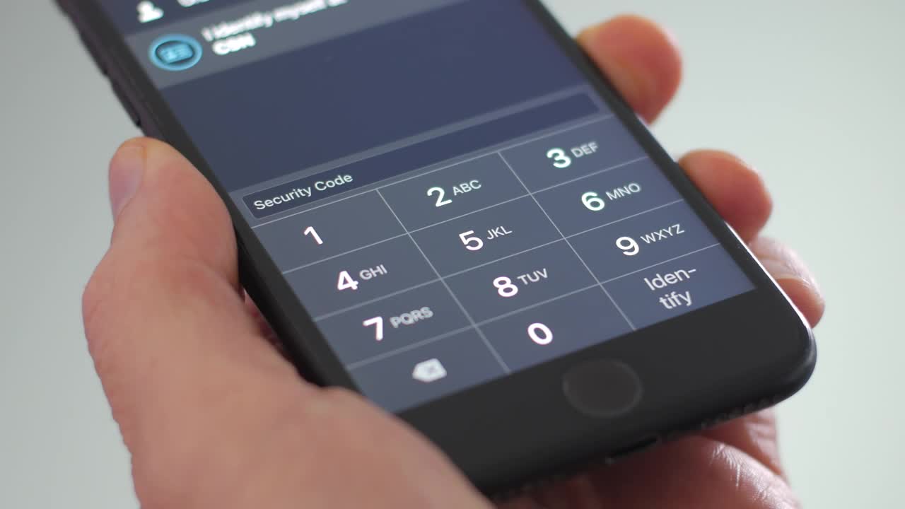 一个人拿着手机，在屏幕上输入数字银行识别码，对角视图视频下载