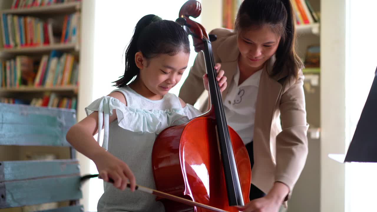 年轻的亚洲女孩学习拉大提琴视频下载