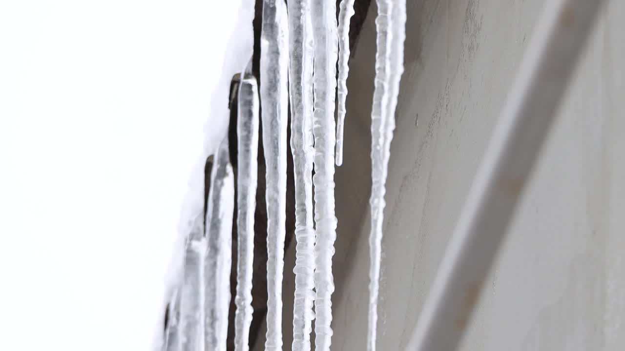 在冬天敲掉屋顶上的冰柱视频素材