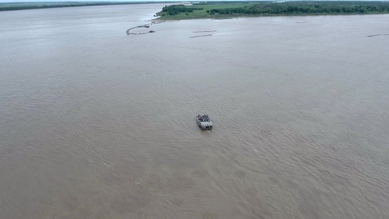航拍一艘载着乘客和摩托车横渡湄公河的小渡船视频素材