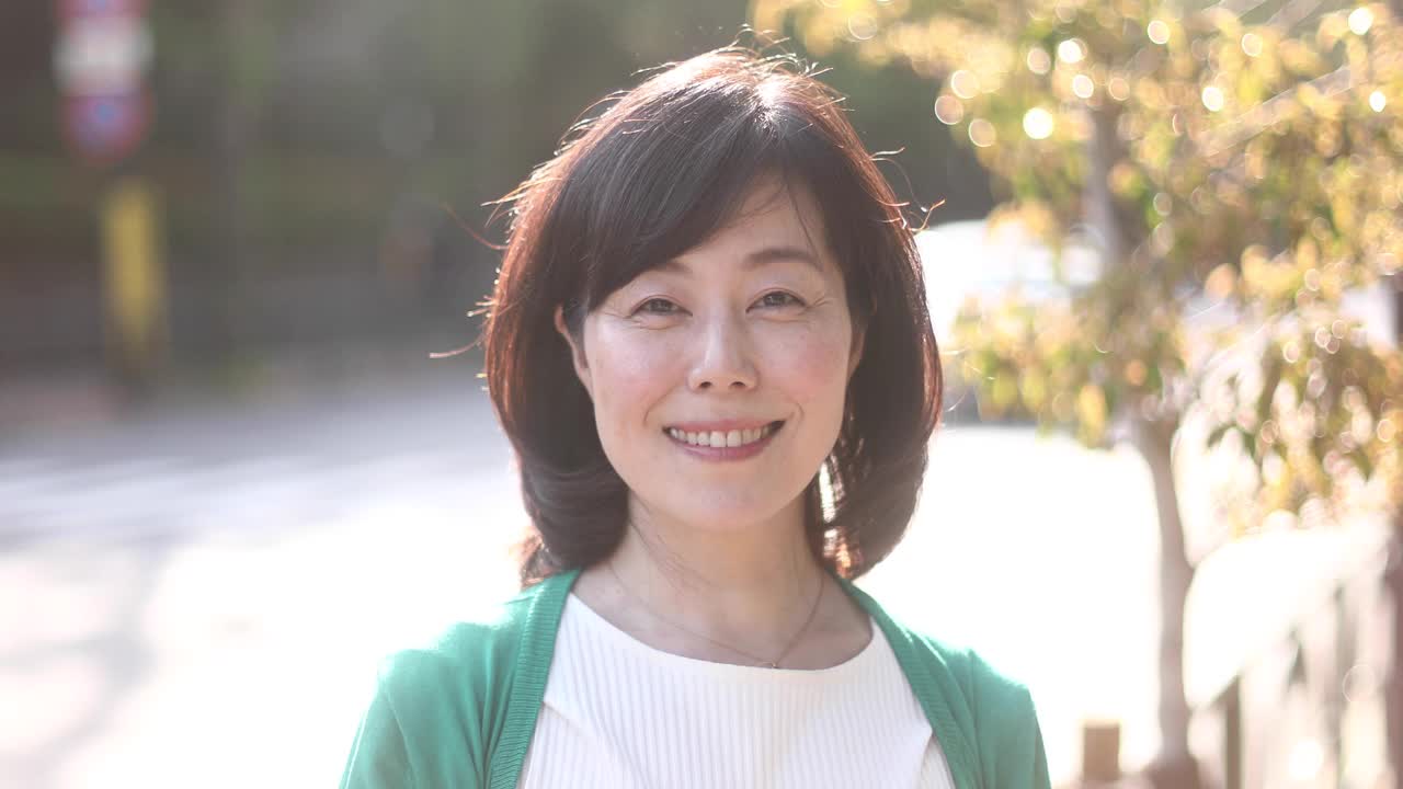 一位日本妇女在街上微笑。视频素材