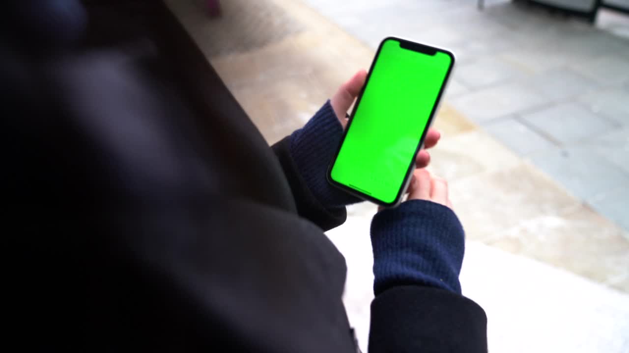 用手拿着绿屏智能手机的女人视频下载