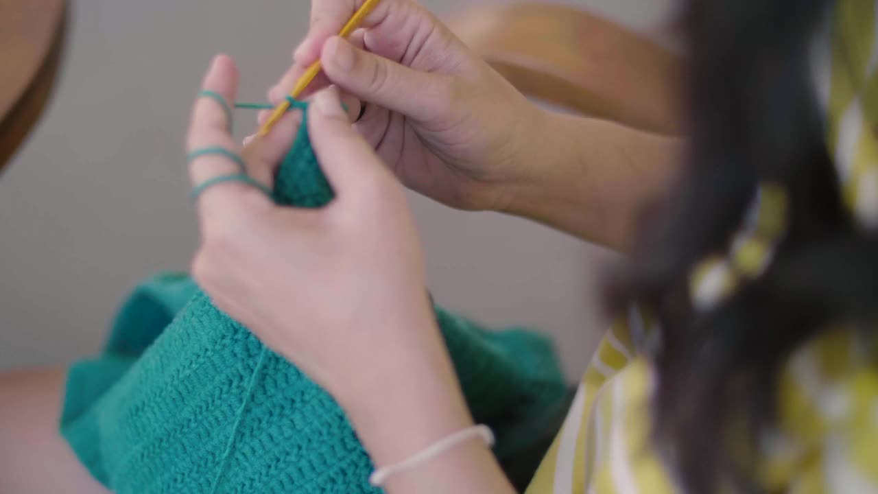 年轻女子在家钩针编织。视频下载