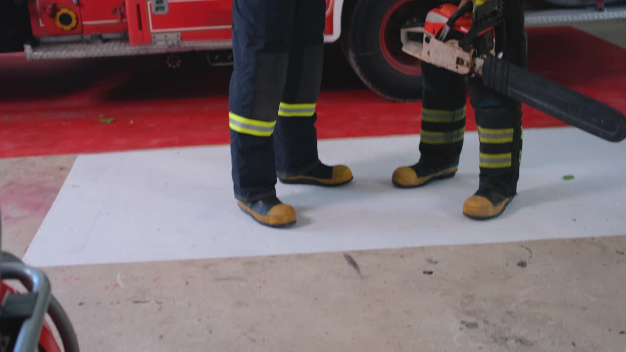 两名消防员握着工具，一起讨论灭火准备工作视频下载