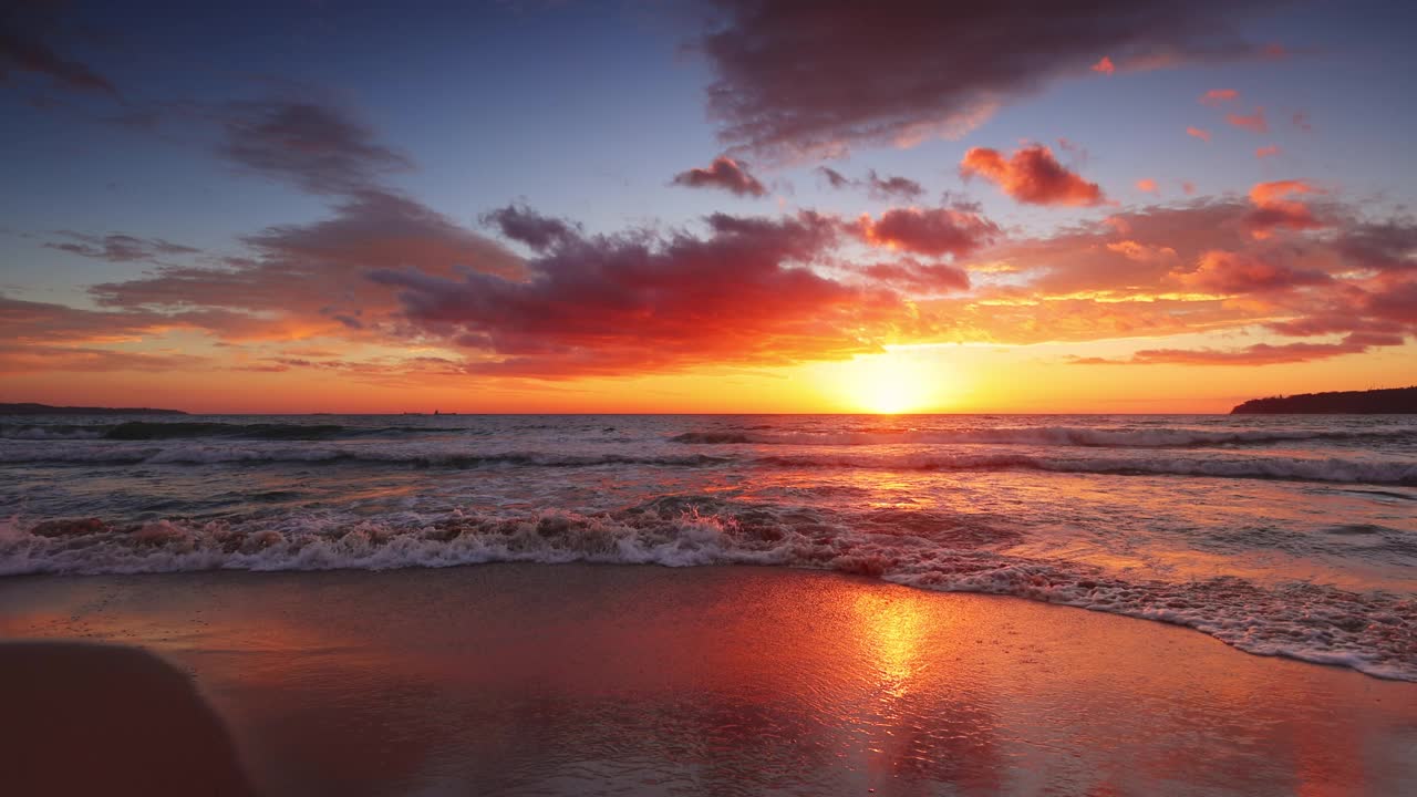 彩色海洋海滩日出。海浪在沙滩上，4k视频视频下载