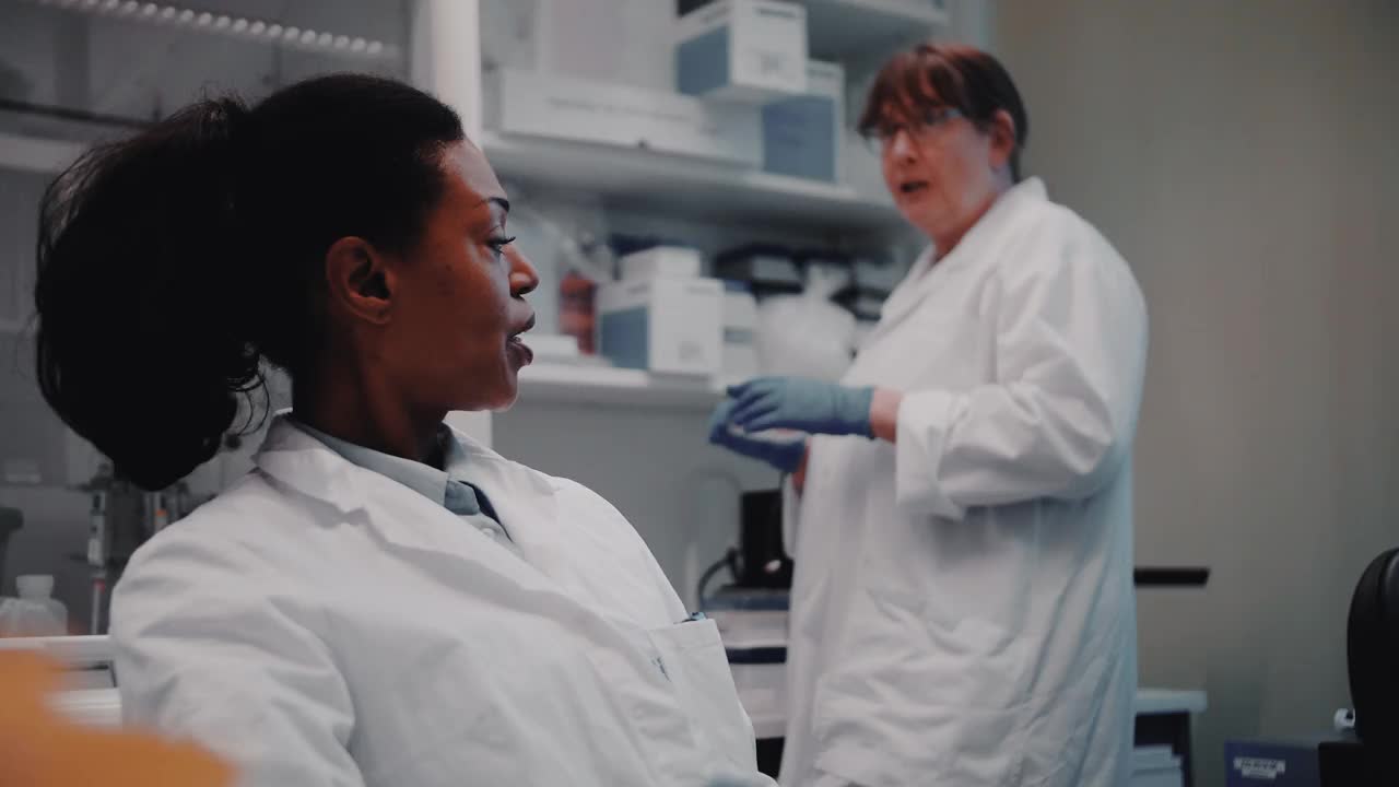 微笑的女科学家在实验室与同事交谈视频素材