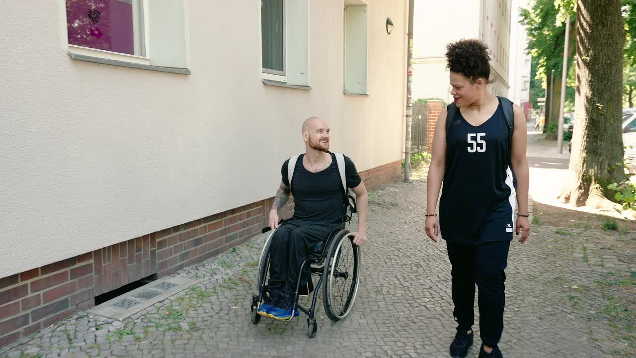 体育妇女和一个坐在轮椅上的残疾人在户外散步视频素材