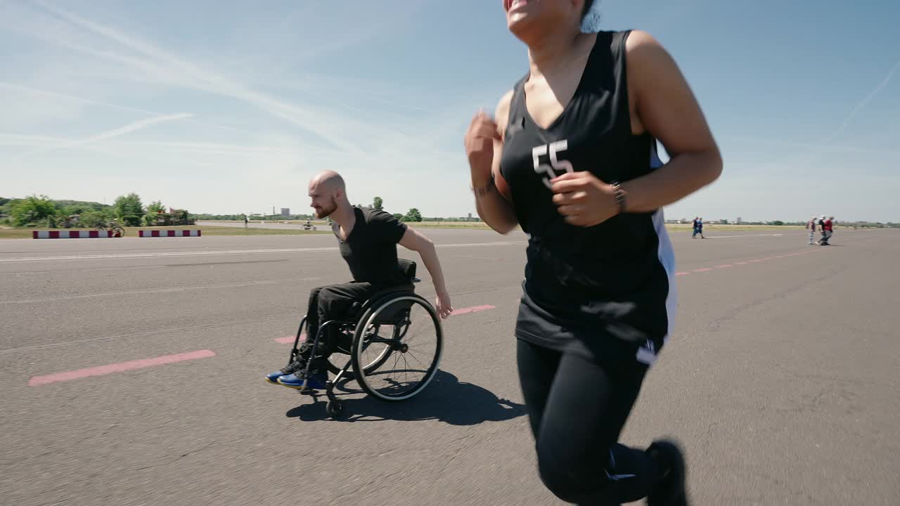 残疾男子骑着轮椅疾驰，女子奔跑视频素材