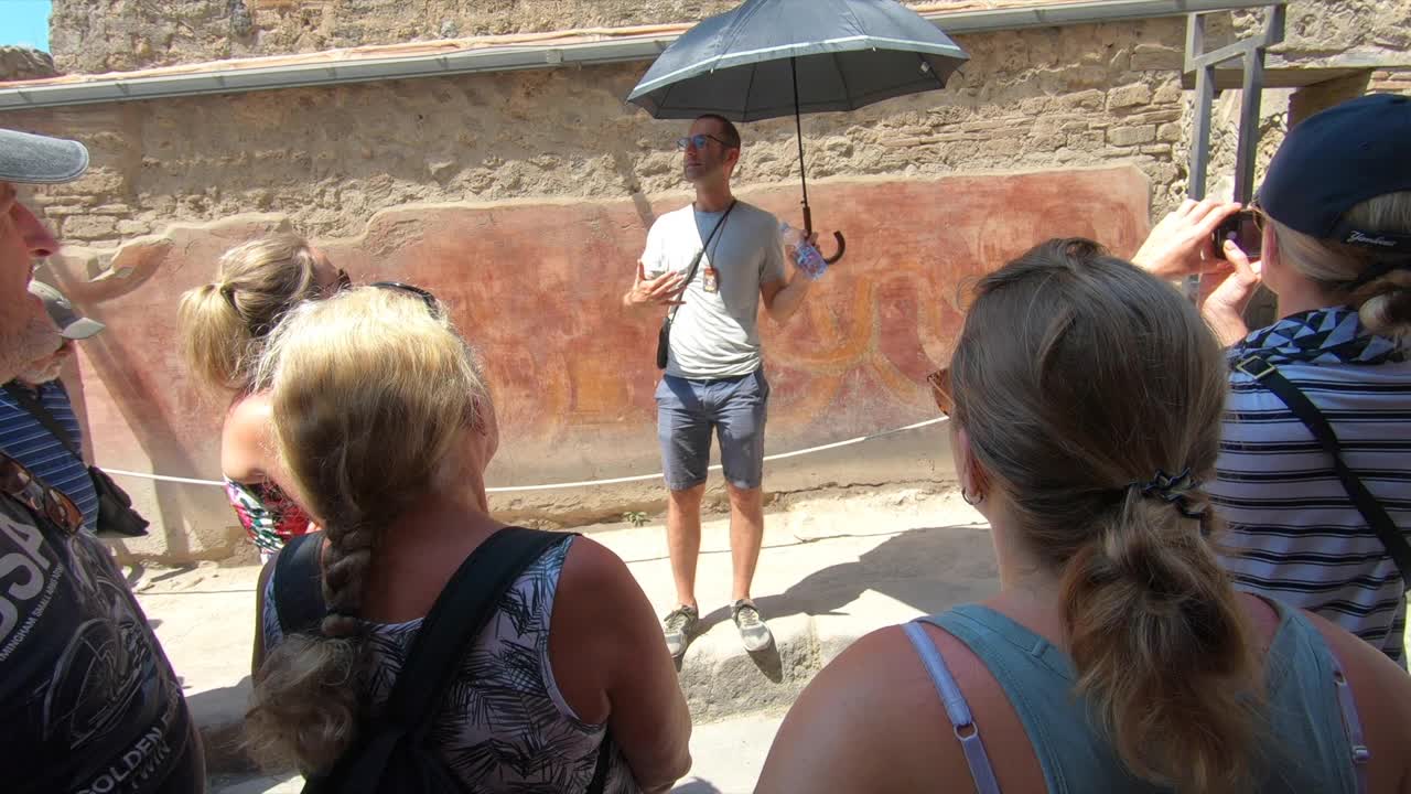 导游带领旅游团游览欧洲意大利庞贝古城遗址。——慢动作视频下载