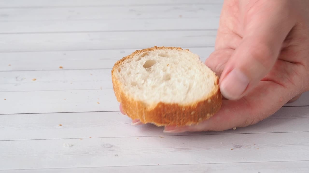 柔软的奶油芝士黄油用刀涂在法式长棍面包片上。做一个美味健康的三明治当早餐点心视频下载