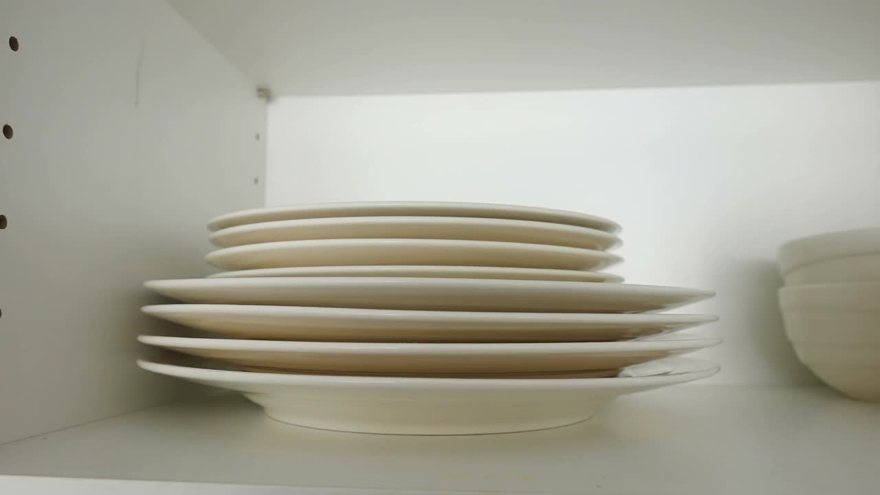 爱沙尼亚的橱柜里堆放着白色的盘子和碗视频素材
