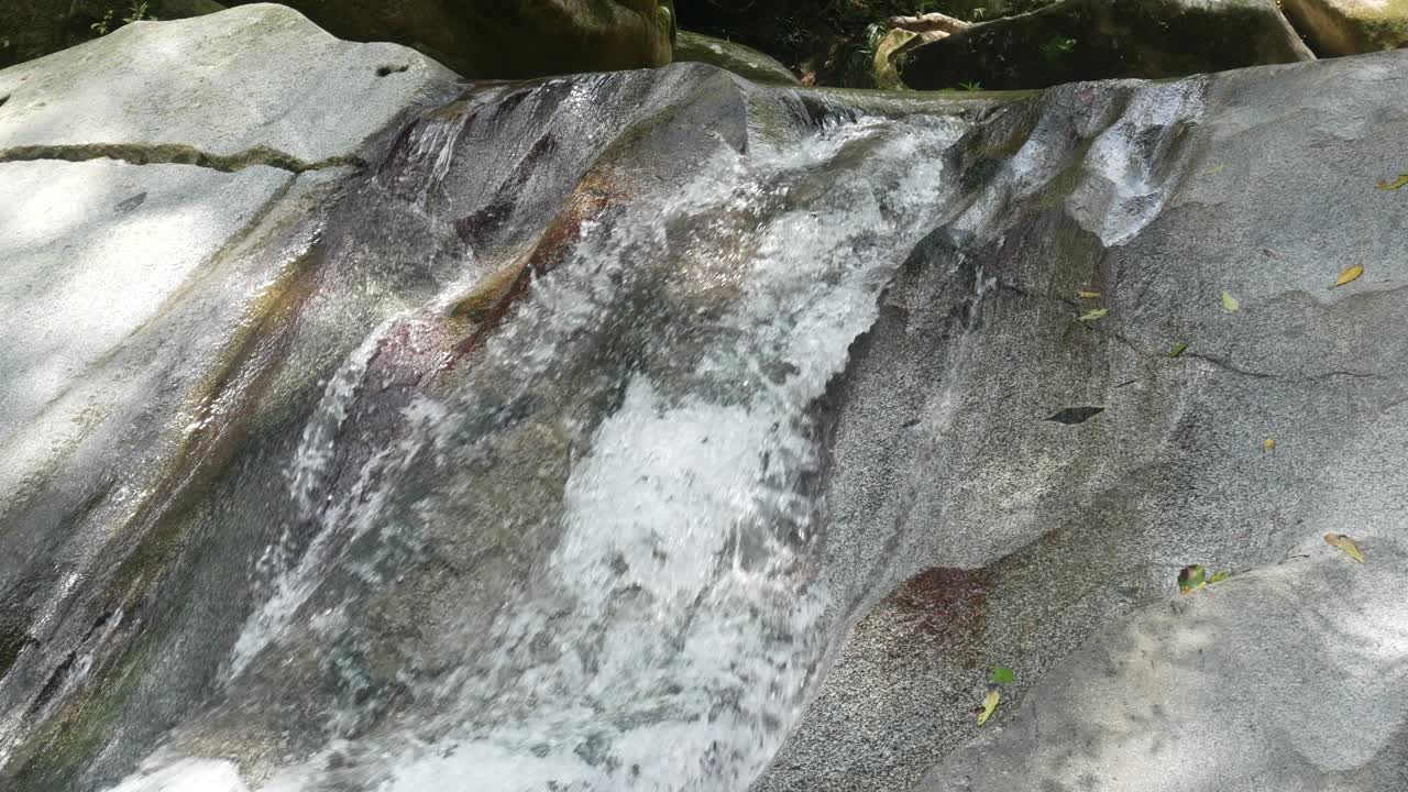 哥伦比亚明卡，从岩石上落下的瀑布形成了一条小溪视频素材