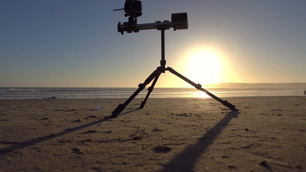 日落时，电子滑块站在沙滩上，慢动作120帧/秒视频素材