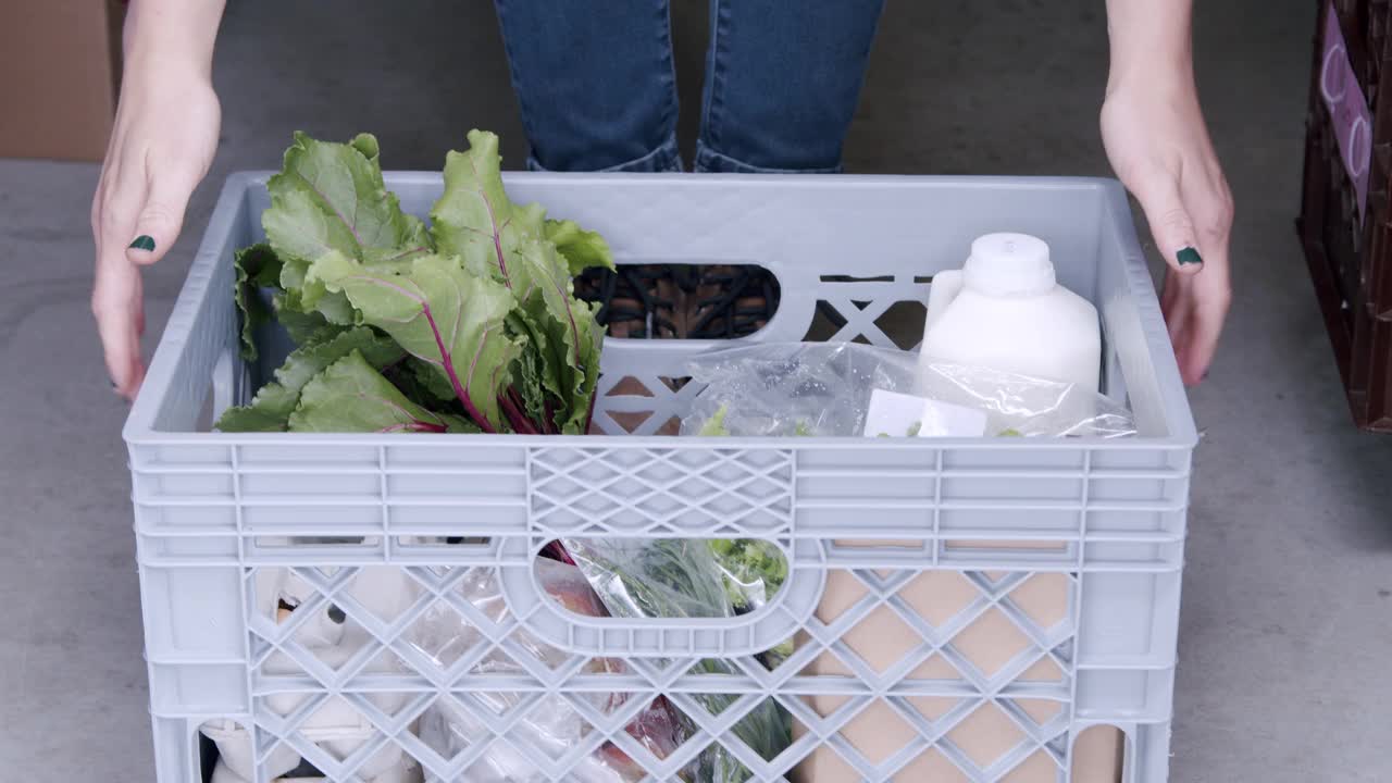 年轻的白人妇女正在挑选一篮子美味的，健康的，有机的农产品，在当地的小型企业农场到餐桌供应商在科罗拉多州视频下载