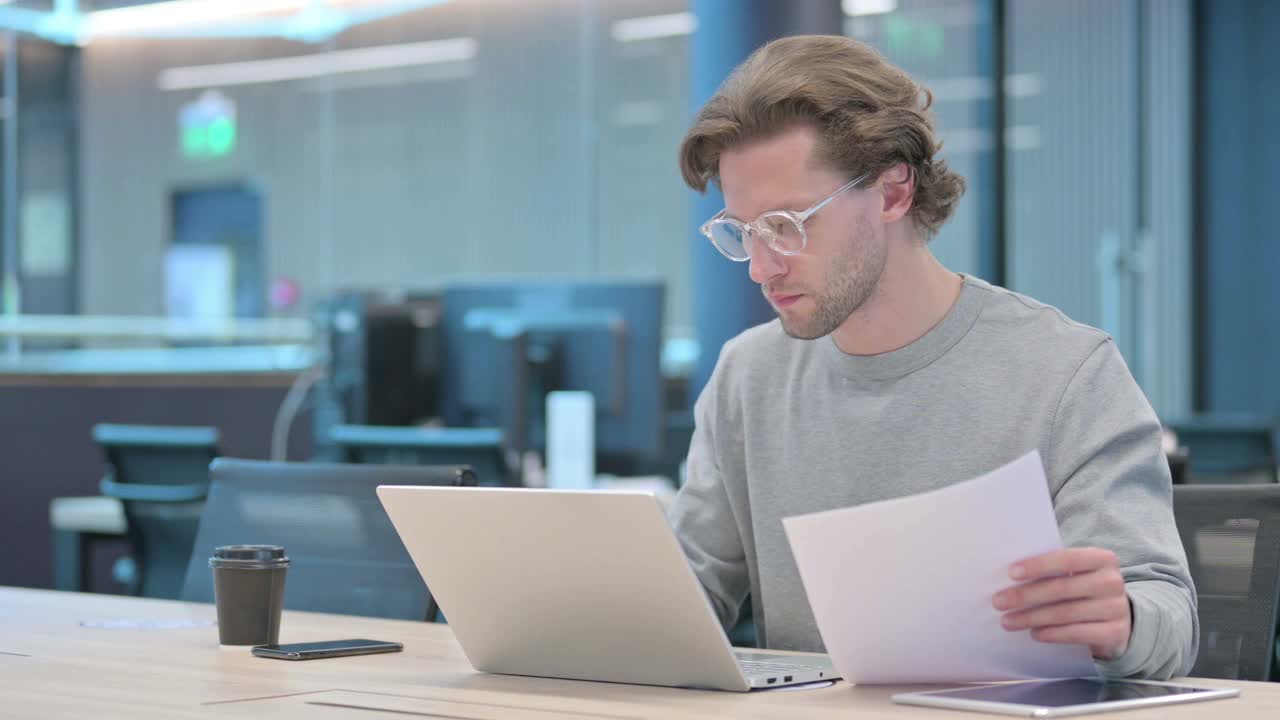年轻的商人用笔记本电脑庆祝文件的成功视频素材