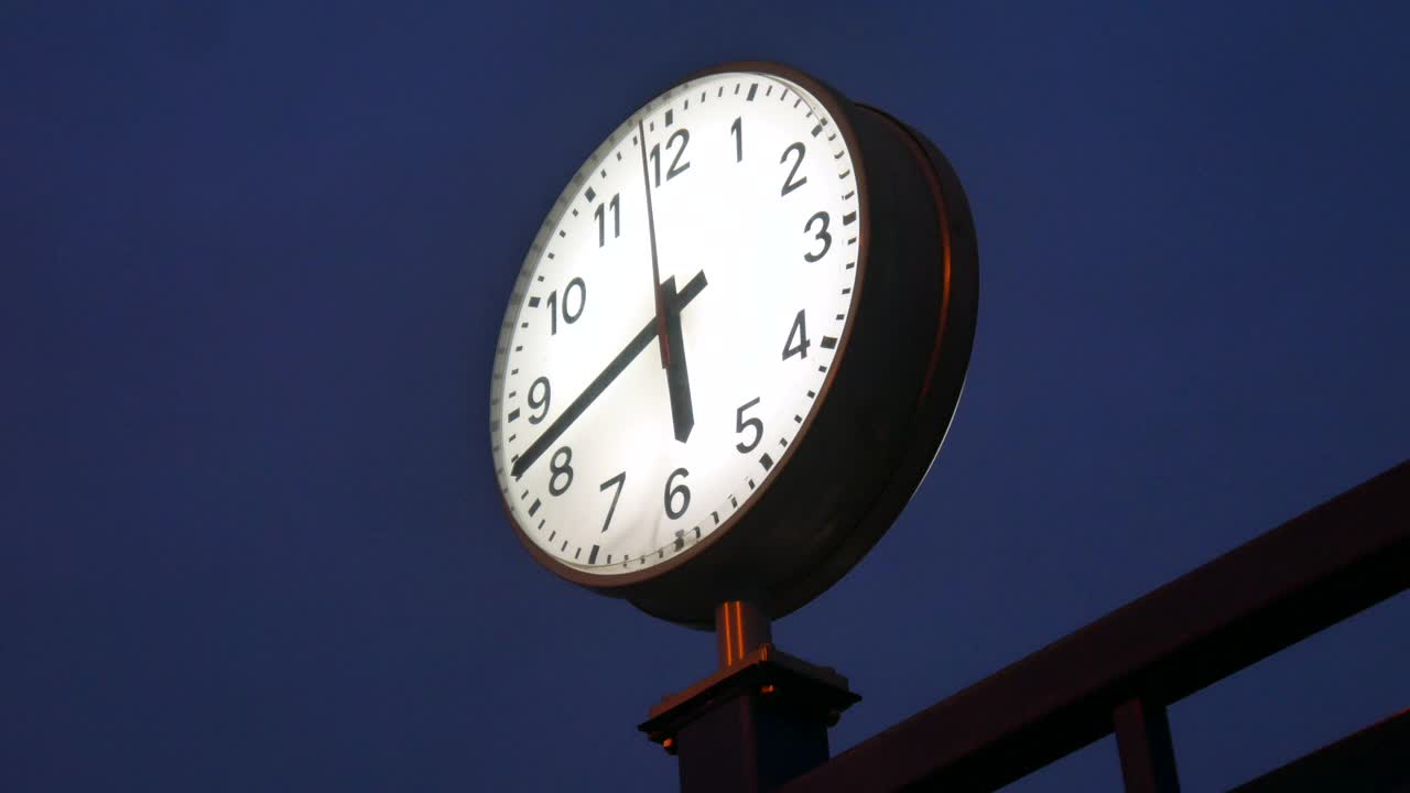 一秒一秒地过去的晚上火车站时钟上的景象。视频下载