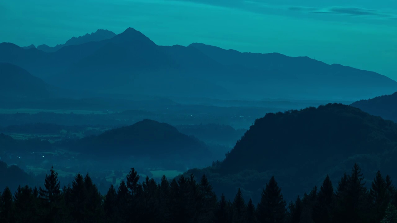 在一个寒冷多雾的早晨，在斯洛文尼亚的流血湖雄伟的山丘上的美丽的日出延时视图。视频下载