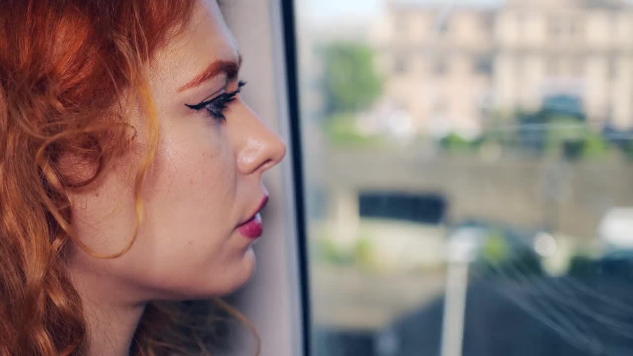 乘火车旅行——火车上一位严肃的年轻女子望着窗外视频素材
